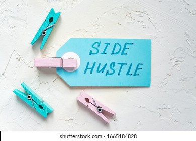 Handwriting Text Side Hustle On A Blue Tag. Concept Of Extra Cash. Colored Clothespin Around.