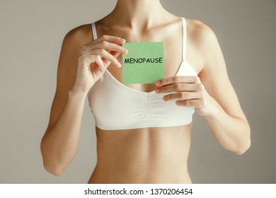 Handwriting Text Writing Menopause. Concept Meaning Cessation Of Menstruation. Young Adult Woman Holding Paper Card For Sign Or Symbol. Cut Out Part Of Body. Medical Problem And Solution.