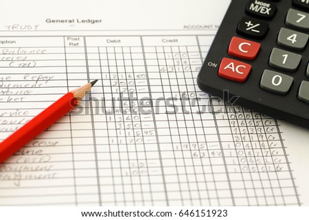 Handwritten Accounting ledger showing bookkeeping using pencil and calculator.