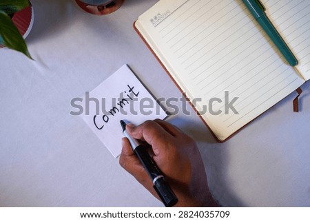 Handwritten Commit reminder on adhesive memo paper,
Commit goal setting concept written on sticky note