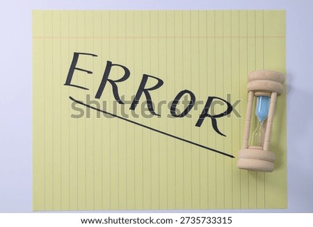 Handwritten ERROR note on yellow legal pad with hourglass representing urgent deadline