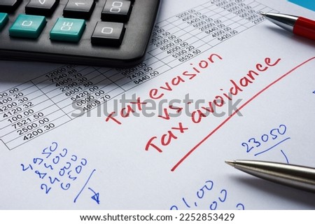 Handwritten inscription tax evasion vs tax avoidance on a piece of paper.