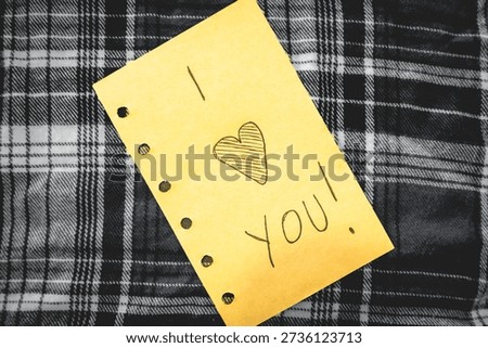 Handwritten I love you note, on a textile background.