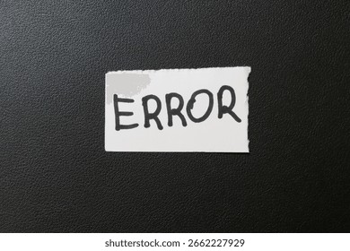 A handwritten note labeled ERROR is placed on a dark textured background. This image symbolizes mistakes, software issues, or failure in various contexts.