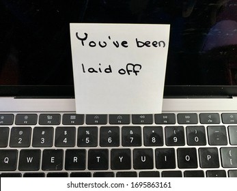 A handwritten note on a computer keyboard stating you’ve been laid off