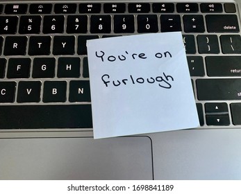 A Handwritten Note On A Computer Keyboard Stating You’re On Furlough. Furlough Is A Leave Of Absence Or A Temporary Layoff From Work