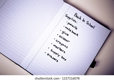 Handwritten Shopping List Of Back To School Supplies Written On Page Of A Notebook