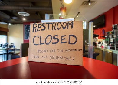 Handwritten Sign At Restaurant Stating Restroom Closed And Take-Out Only And Sorry Ofr The Inconvenience Due To Coronavirus Pandemic. 