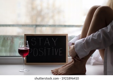 Handwritten Stay Positive Sign On The Chalkboard. A Woman Sitting On The Windowsill With A Glass Of Wine. Motivational Words