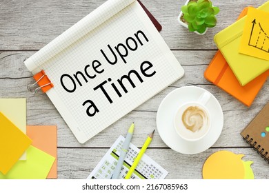 Handwritten text "Once Upon a Time" on a notepad next to a pen. close-up.
