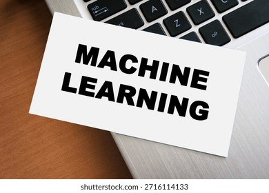 Handwritten text reading MACHINE LEARNING on a white card, placed on a laptop keyboard. This image represents technology, education, and innovation in the digital age.