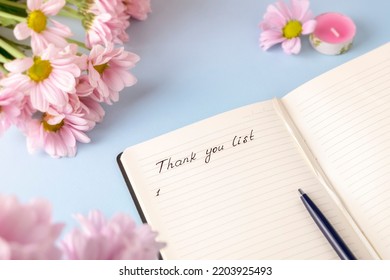 Handwritten Words Thank You List In A Personal Diary On A Light Blue Background With Pink Flowers. Gratitude Journal Concept