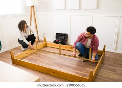 Handy Man And Caucasian Woman Building A Self Assembly Bed Frame And Furniture For Their New Bedroom