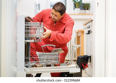 Handy Man Fixing A Broken Dishwasher In The Kitchen