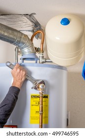 Handy Man Tightens Fitting On A Hot Water Heater