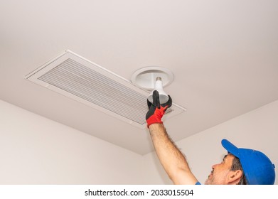 Handyman Changing A Overhead Flood Light Indoors