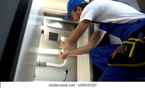 Handyman checking clogged water pipe, installing faucet plumbing, repair service - Powered by Shutterstock