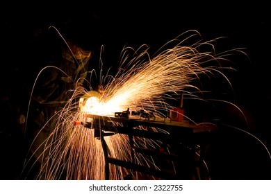 Handyman creating sparks in while cutting steel