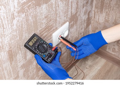 Handyman Electrician Measuring Wall Outlet Voltage At Living Room. Outlet Repair Concept. Test House Wiring Conceptual.