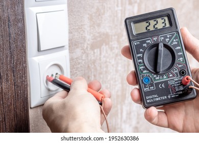 Handyman Electrician Measuring Wall Outlet Voltage At Living Room. Outlet Repair Concept. Test House Wiring Conceptual.