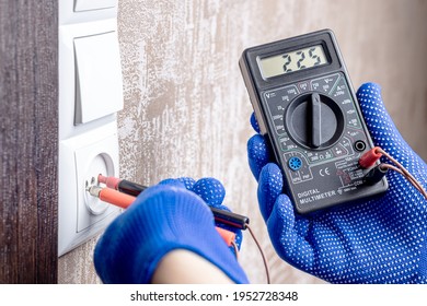 Handyman Electrician Measuring Wall Outlet Voltage At Living Room. Outlet Repair Concept. Test House Wiring Conceptual.