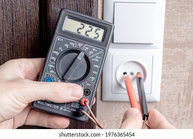 Handyman Electrician Measuring Wall Outlet Voltage At Living Room. Outlet Repair Concept. Test House Wiring Conceptual.