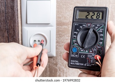 Handyman Electrician Measuring Wall Outlet Voltage At Living Room. Outlet Repair Concept. Test House Wiring Conceptual.