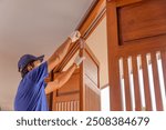 Handyman fixing bifold doors sticking or not sliding properly.