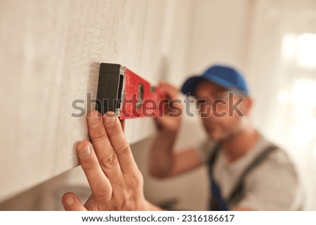 Handyman fixing kitchen cabinets in the apartment.