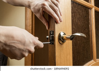 handyman fixing or repairing apartment wooden door lock. home furniture adjusting. door repair concept.