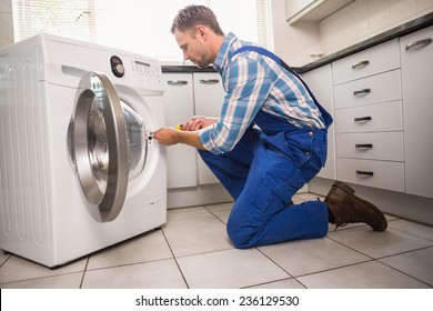 Handyman Fixing A Washing Machine In The Kitchen