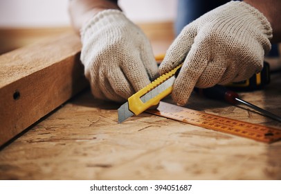 Handyman In Gloves Working With Wood On The Floor. Concept Of Home Reconstruction And Furniture Improvement. 