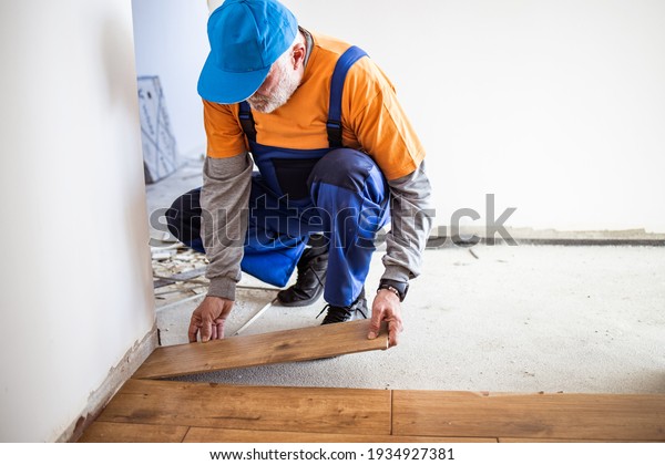 Handyman\
installing ceramic tiles in brand new\
building