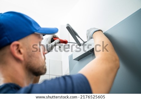 Handyman Installing And Fixing Automatic Door Closer. Maintenance And Service