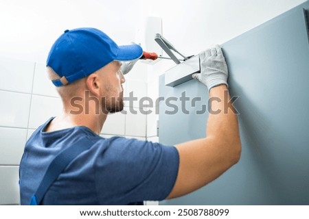 Handyman Installing And Fixing Automatic Door Closer. Maintenance And Service