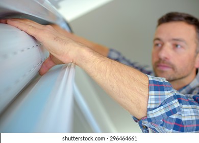 Handyman Installing A Window Shutter