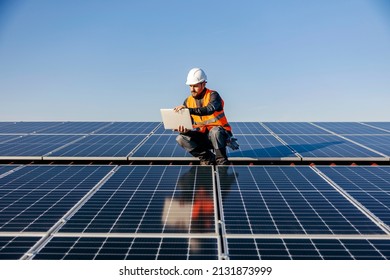 A handyman looking at the laptop on rooftop and testing solar panels. - Powered by Shutterstock