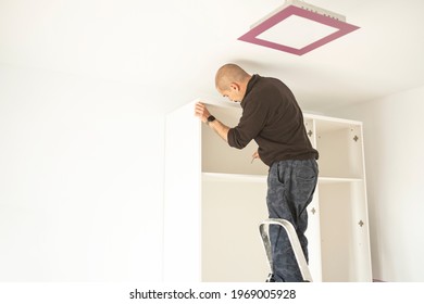 Handyman Man Assembling A Closet In A Moving House