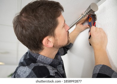 handyman marking drill holes with a spirit level