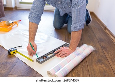 Handyman Measuring Wallpaper To Cut