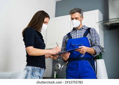 Handyman Plumber And Customer With Service Contract On Clipboard In Face Mask