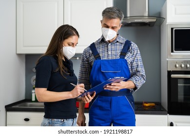 Handyman Plumber And Customer With Service Contract On Clipboard In Face Mask