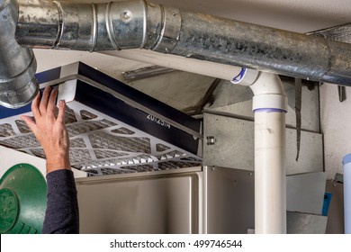 Handyman Replaces A Furnace Filter With A Clean One