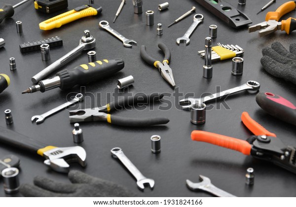 Handyman tool kit on black\
wooden table. Many wrenches and screwdrivers, pilers and other\
tools for any types of repair or construction works. Repairman\
tools set
