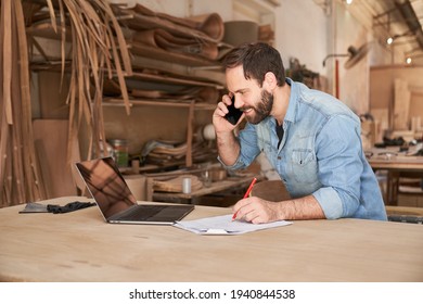 Handyman Using Phone And Laptop Computer When Scheduling In Workshop