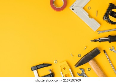 Handyman's tools. Flat lay of clamps, wrench, screwdriver, drill, angle, bubble level and tape measure on yellow background. Happy Father's Day. Free space  for you text - Powered by Shutterstock