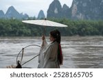 Hanfu model girl holds Deng umbrella spinning it slightly as bird flaps wings. Photo session in China