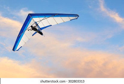 Hang glider fling over the ocean at sunset