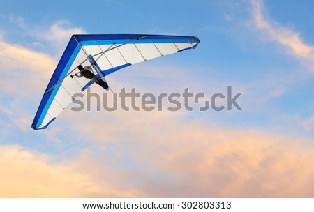 Hang glider fling over the ocean at sunset