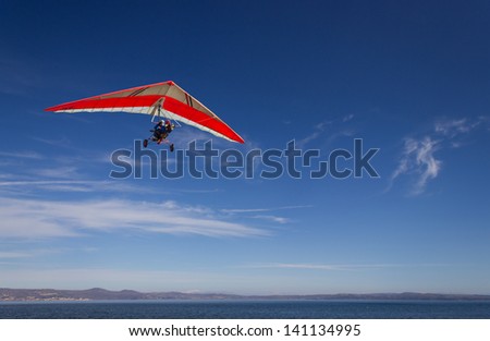 an hang glider flying over Bracciano lake, near Rome, italy in a very clear, sunny day